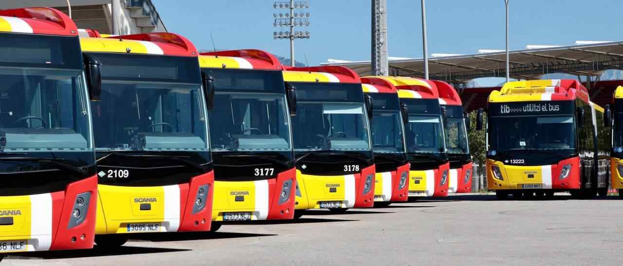 Varios autobuses amarillos y rojos de la red TIB alineados en una cochera