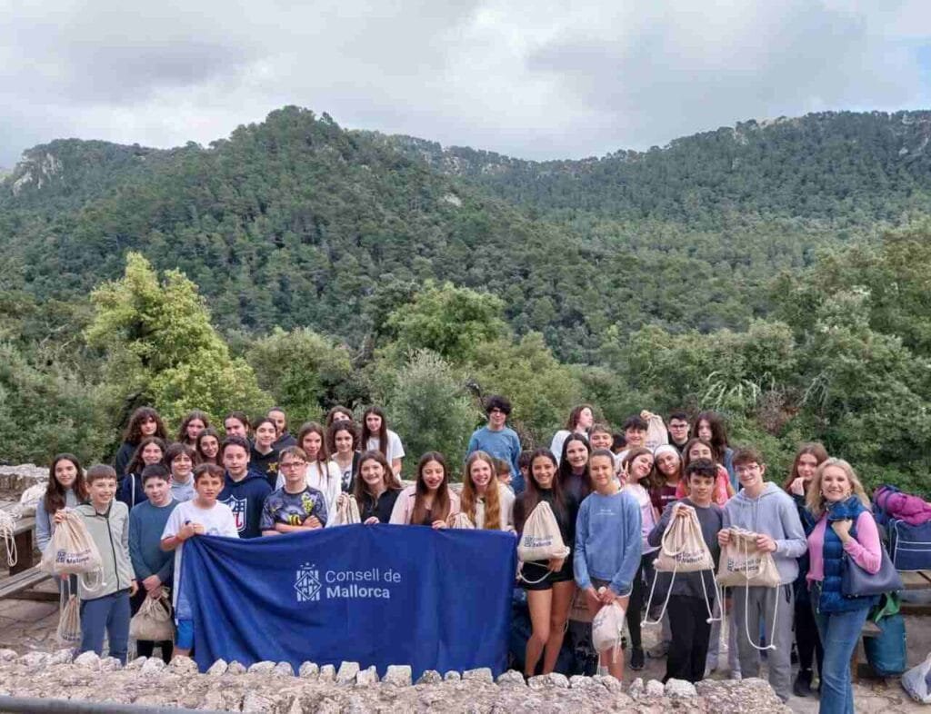 Grupo de jóvenes participantes posando con mochilas azules del Consell de Mallorca