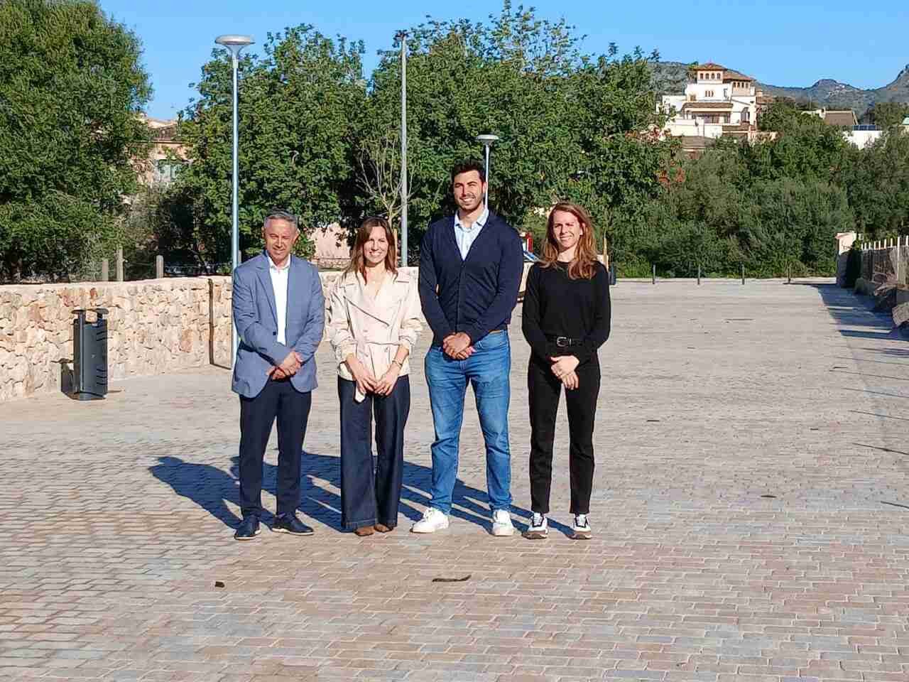 El alcalde y representantes municipales de Sant Llorenç des Cardassar posando en una zona peatonal adoquinada y urbanizada, tras la recepción de las obras de dotación de servicios para la parcela del futuro instituto