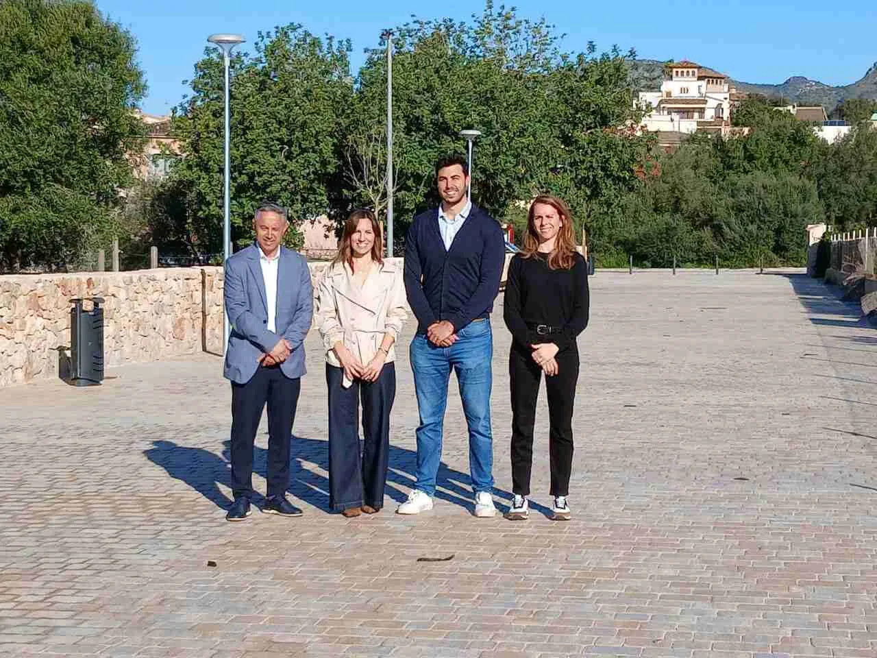 El alcalde y representantes municipales de Sant Llorenç des Cardassar posando en una zona peatonal adoquinada y urbanizada, tras la recepción de las obras de dotación de servicios para la parcela del futuro instituto