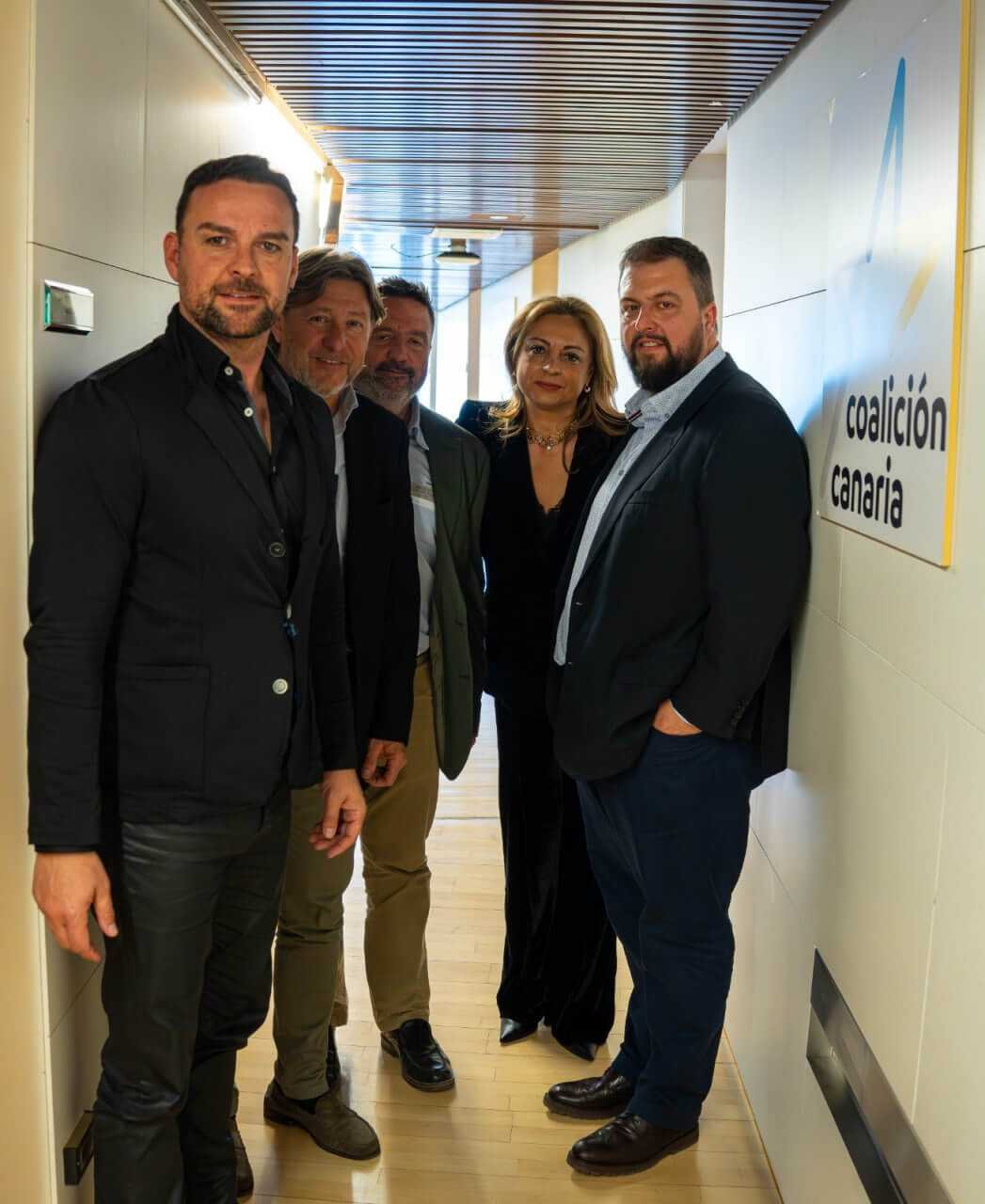 Representantes de Coalició per Mallorca y la diputada Cristina Valido en un pasillo del Congreso de los Diputados, junto a un cartel de Coalición Canaria