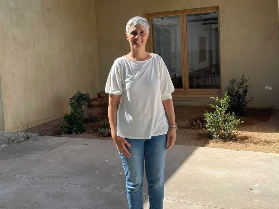 Xesca Mir, Secretaria General del PSOE de Sa Pobla, posando frente a un edificio