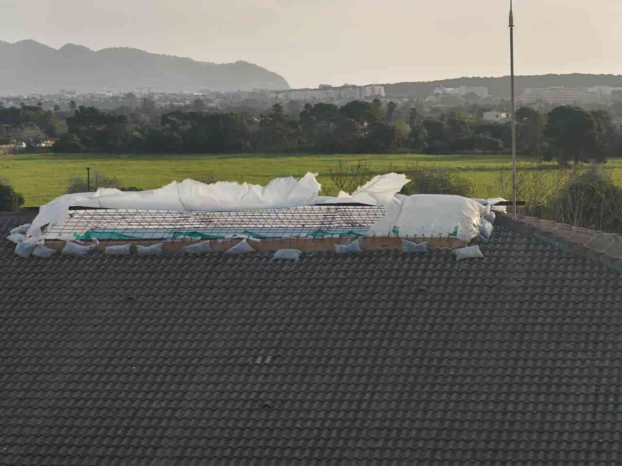 Lona provisional del tejado del colegio Mitjà de Mar rasgada y destrozada por el viento