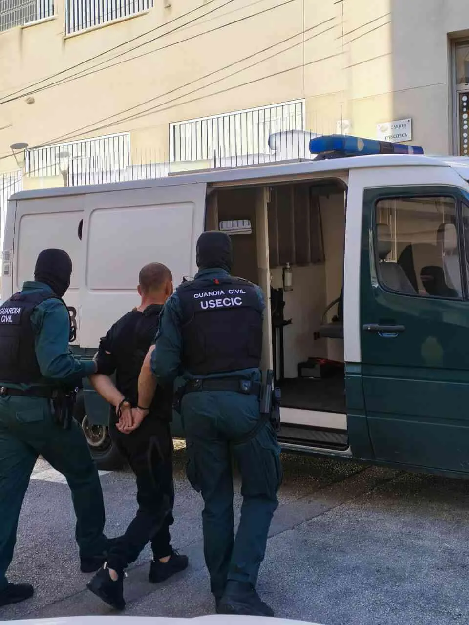 Agentes de la Guardia Civil escoltando a un detenido marroquí hacia el furgón en Inca