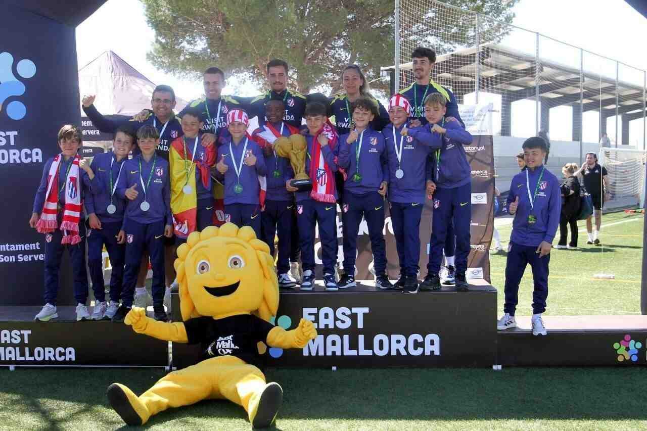Los jugadores del Atlético de Madrid celebrando con el trofeo y sus medallas en el podio de Cala Millor