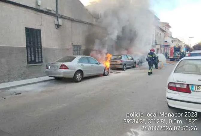 Un vehículo envuelto en llamas y una gran columna de humo en una calle de Manacor