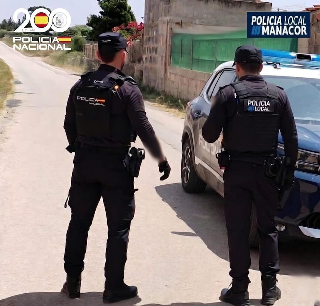 Un agente de la Policía Nacional y otro de la Policía Local de Manacor junto a un vehículo policial en una zona de parcelas