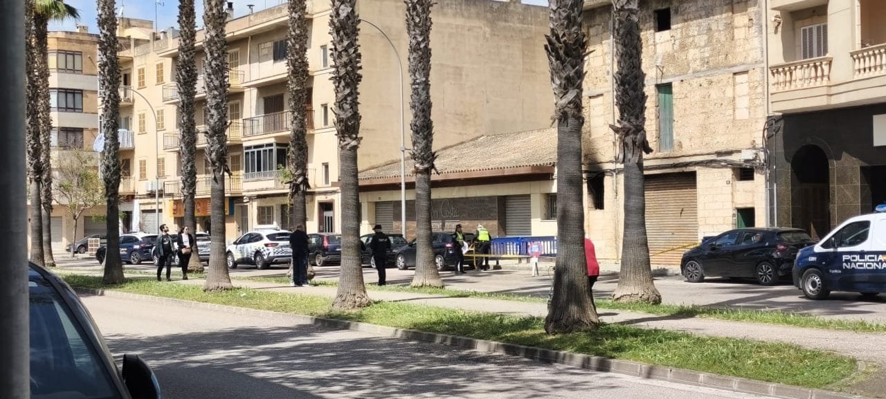 Vehículo de la Policía Nacional frente a la casa con marcas de humo en la fachada