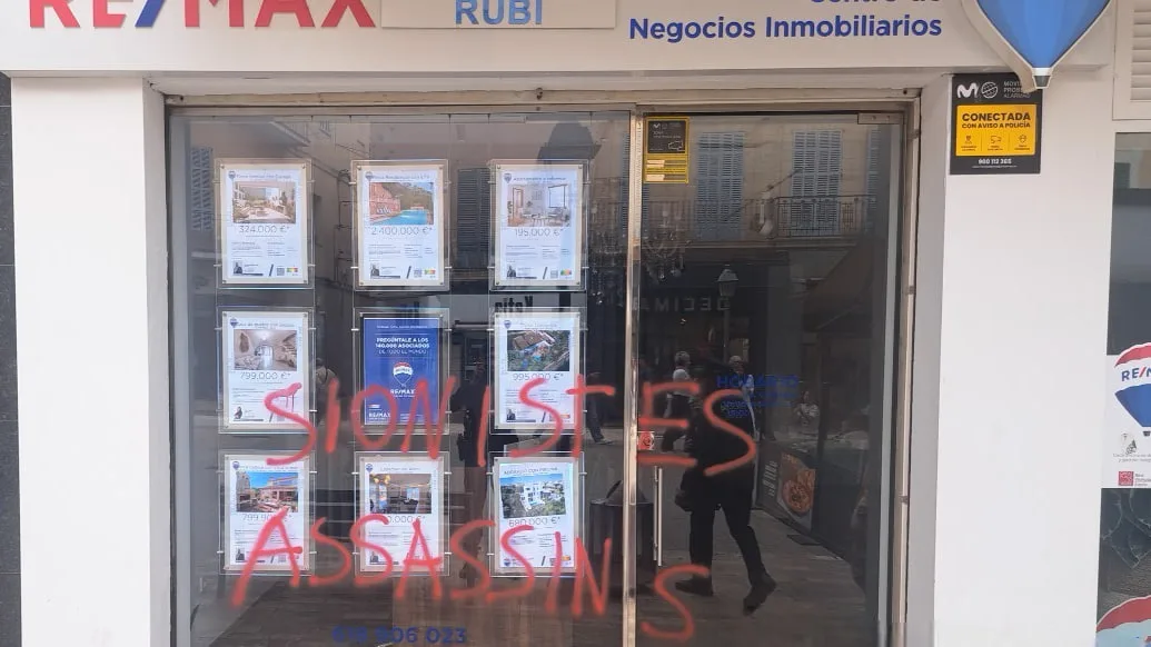 Escaparate de cristal con la pintada roja "Sionistes Assassins" en la Plaza de sa Bassa