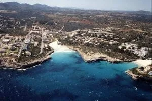 Vista aérea de la costa de Cala Mandia en Manacor con el mar azul y las edificaciones cercanas