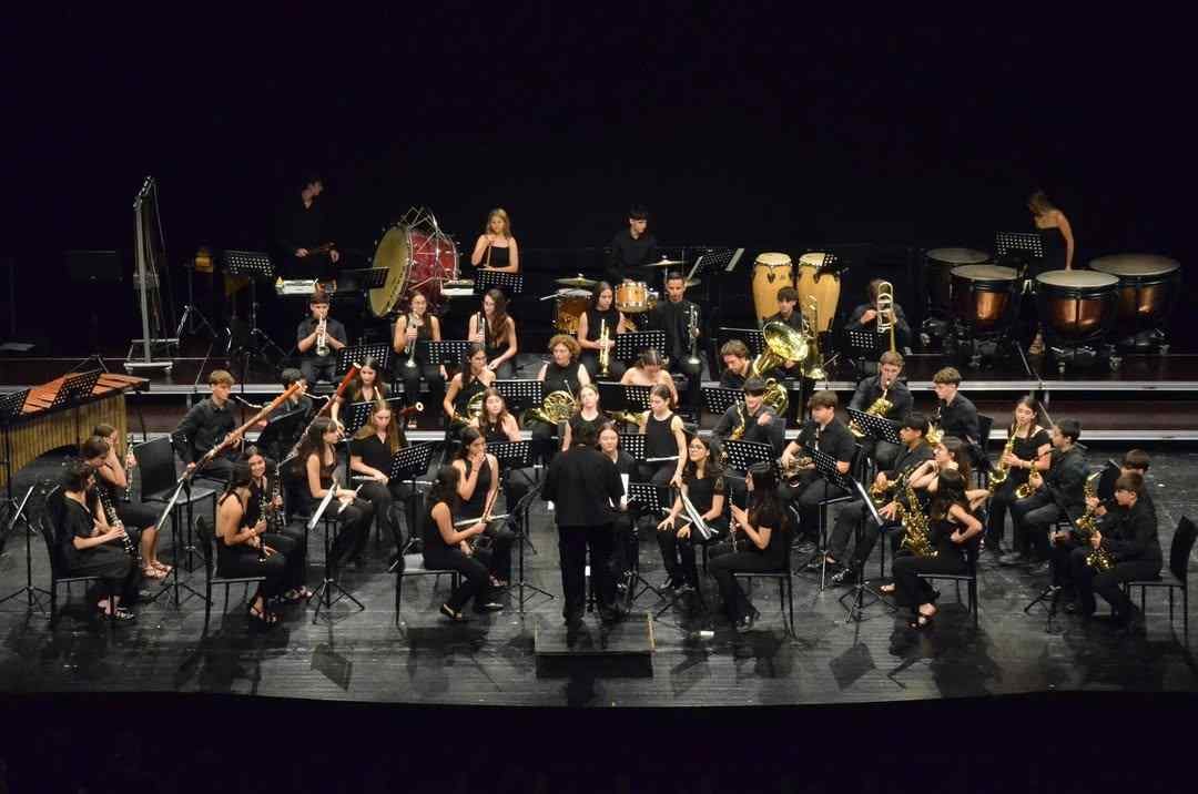 Alumnos de la banda de música del Conservatorio de Manacor tocando instrumentos de viento y percusión en el escenario del Auditori