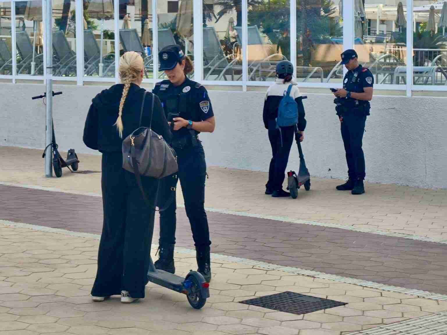 Agentes de la Policía Local de Son Servera controlando a usuarias de patinete eléctrico en el paseo marítimo