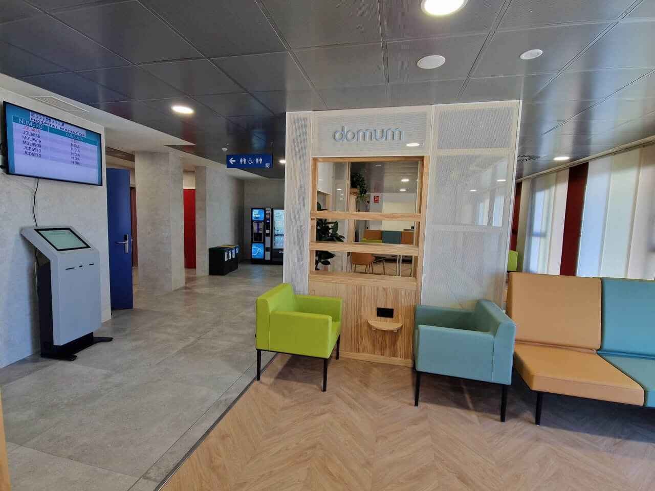 Zona de espera interior del nuevo Hospital de Día de Manacor con mobiliario de diseño y pantallas informativas