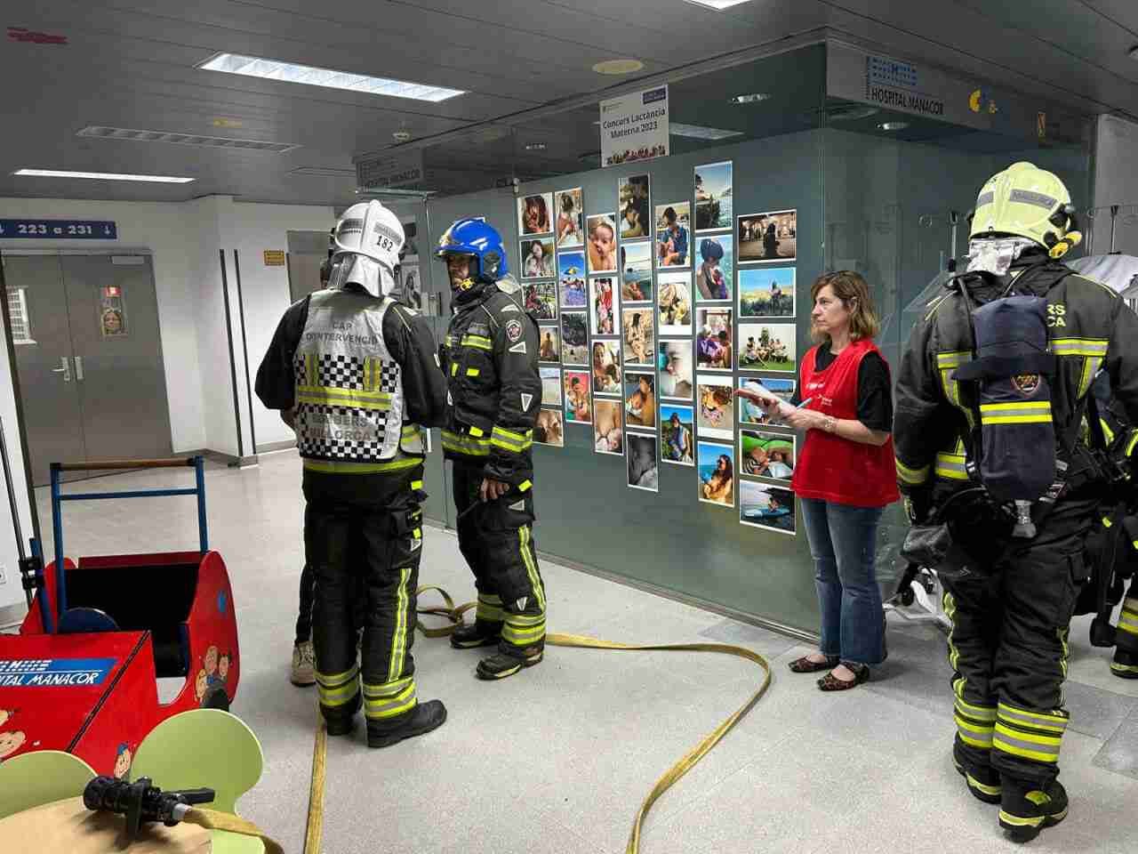 Bomberos de Mallorca desplegando mangueras en el pasillo del Hospital de Manacor junto a personal sanitario durante un simulacro