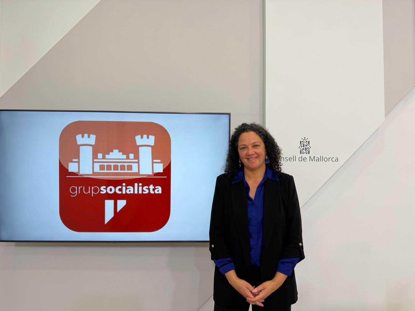 Catalina Cladera, portavoz del PSOE, junto a una pantalla con el logotipo del Grupo Socialista en el Consell de Mallorca