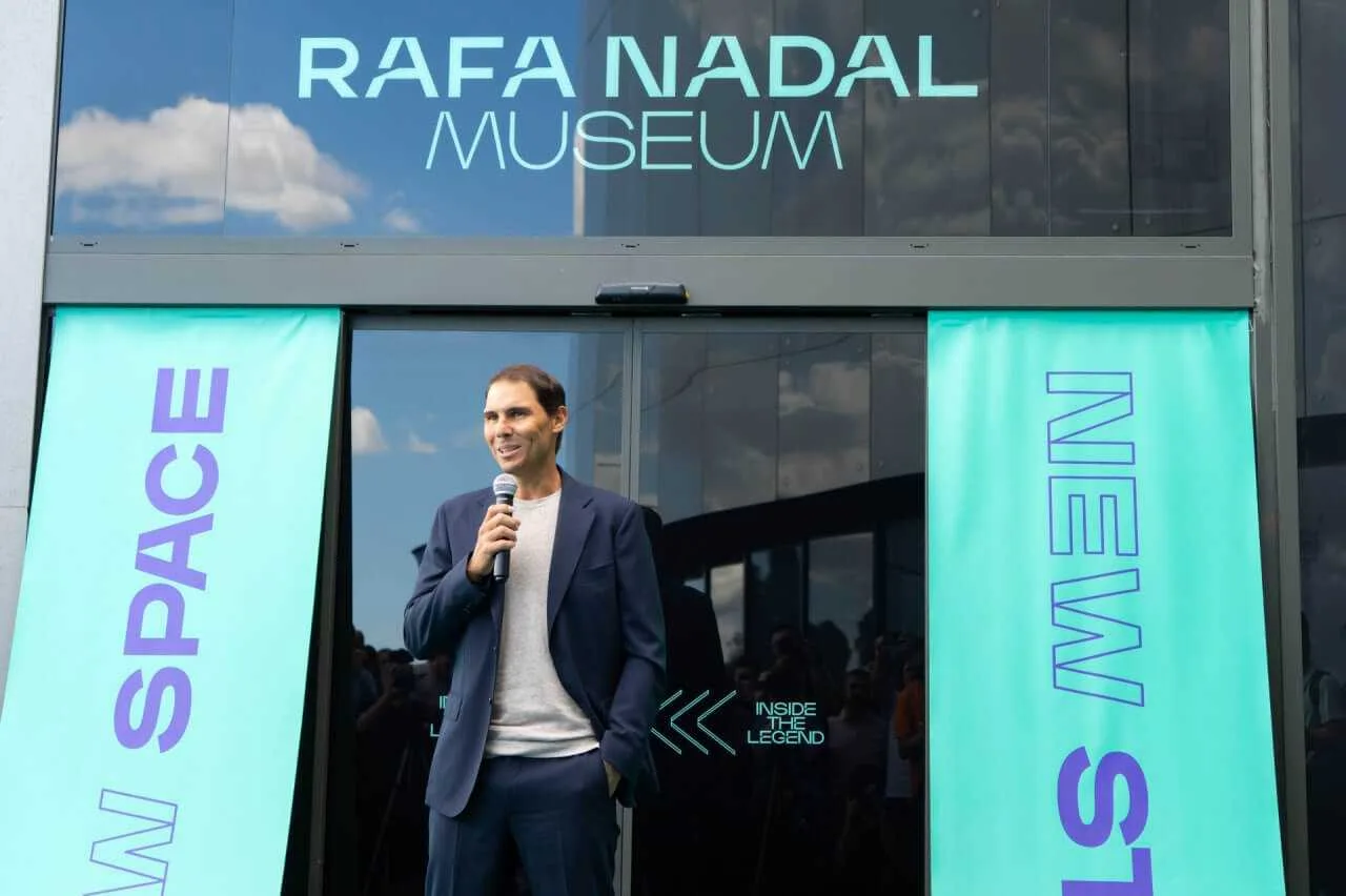 Rafa Nadal hablando con un micrófono frente a la entrada de su nuevo museo Inside the Legend en Manacor