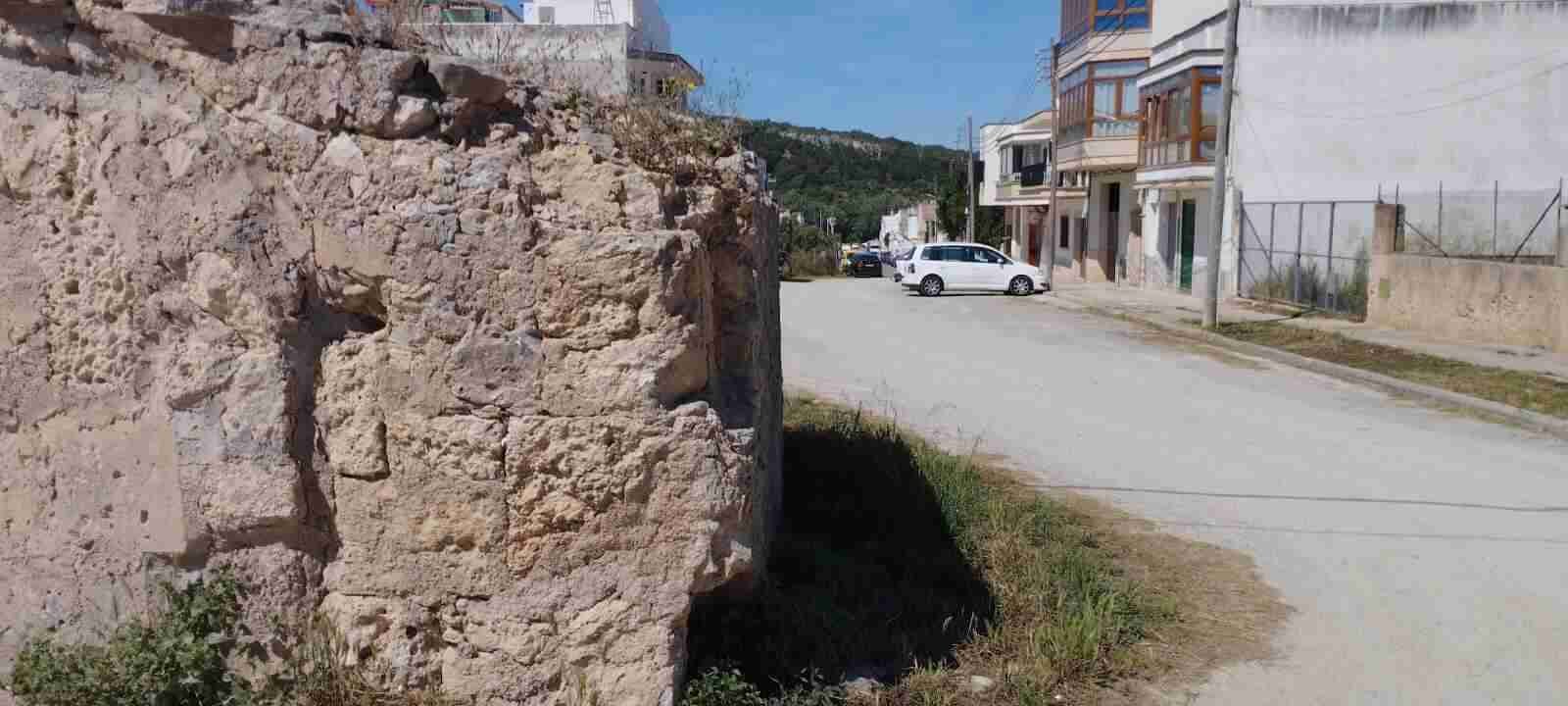 Perspectiva de una calle estrecha y empedrada con fachadas de casas tradicionales en Felanitx