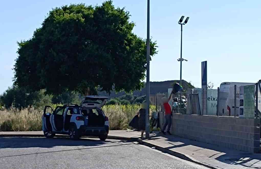 Personas abandonando bolsas de basura junto al recinto de la deixalleria de Felanitx.