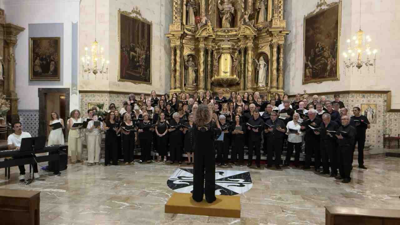 Componentes de la coral vestidos de blanco y negro cantando en el concierto del Convent de Manacor