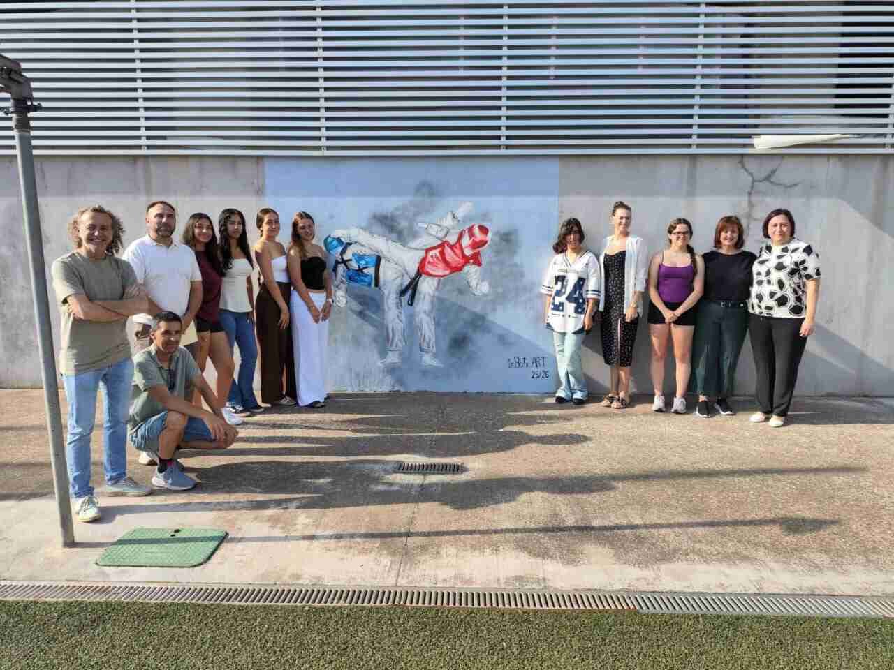 Alumnos y autoridades de Son Servera frente al nuevo mural del polideportivo