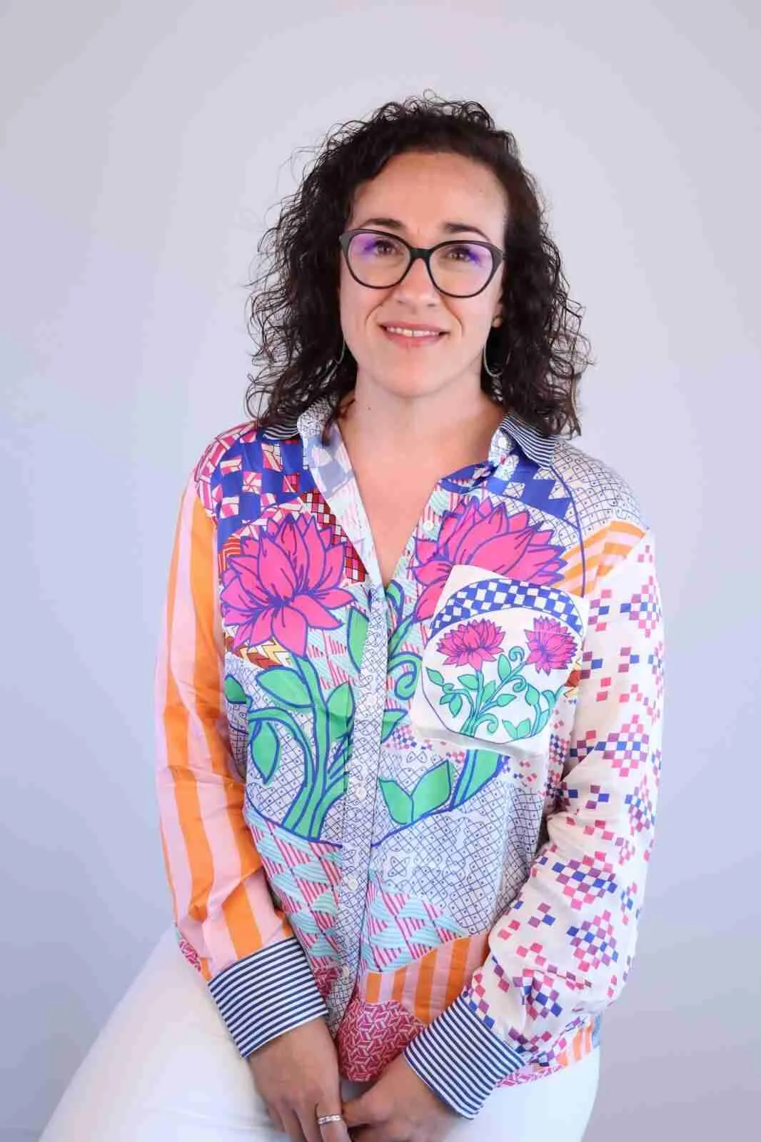 Retrato de la consejera socialista Juana Maria Adrover sonriendo con gafas y blusa estampada