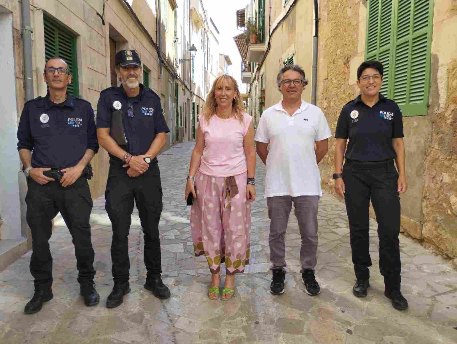 La alcaldesa Catalina Soler junto a miembros del Ayuntamiento y tres agentes de la Policía Local de Felanitx en una calle peatonal