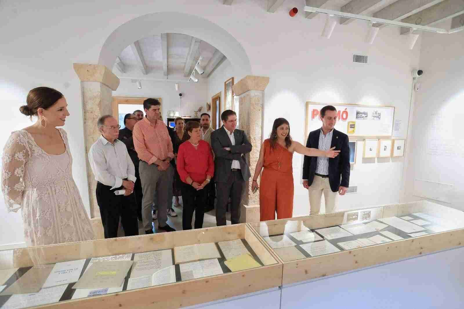 Autoridades y familiares observando los documentos del legado de Miquel Àngel Riera expuestos en vitrinas