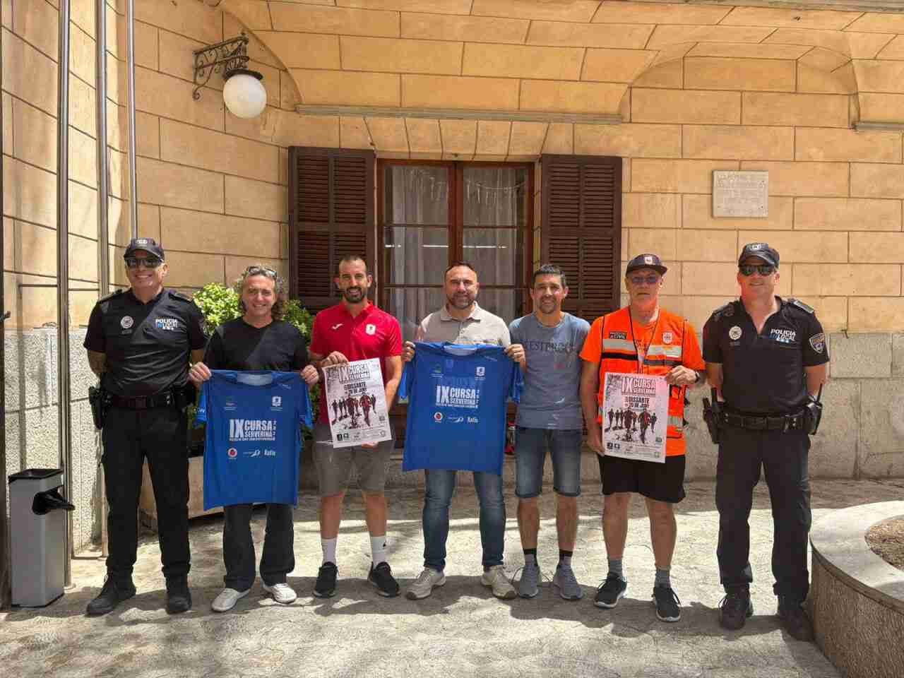 Representantes municipales, organizadores y colaboradores mostrando las camisetas y carteles de la IX Cursa Serverina