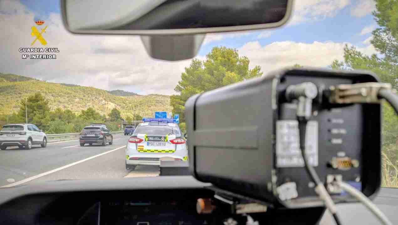 Vista desde el interior de un coche radar de la Guardia Civil con un cinemómetro apuntando a la carretera en Mallorca