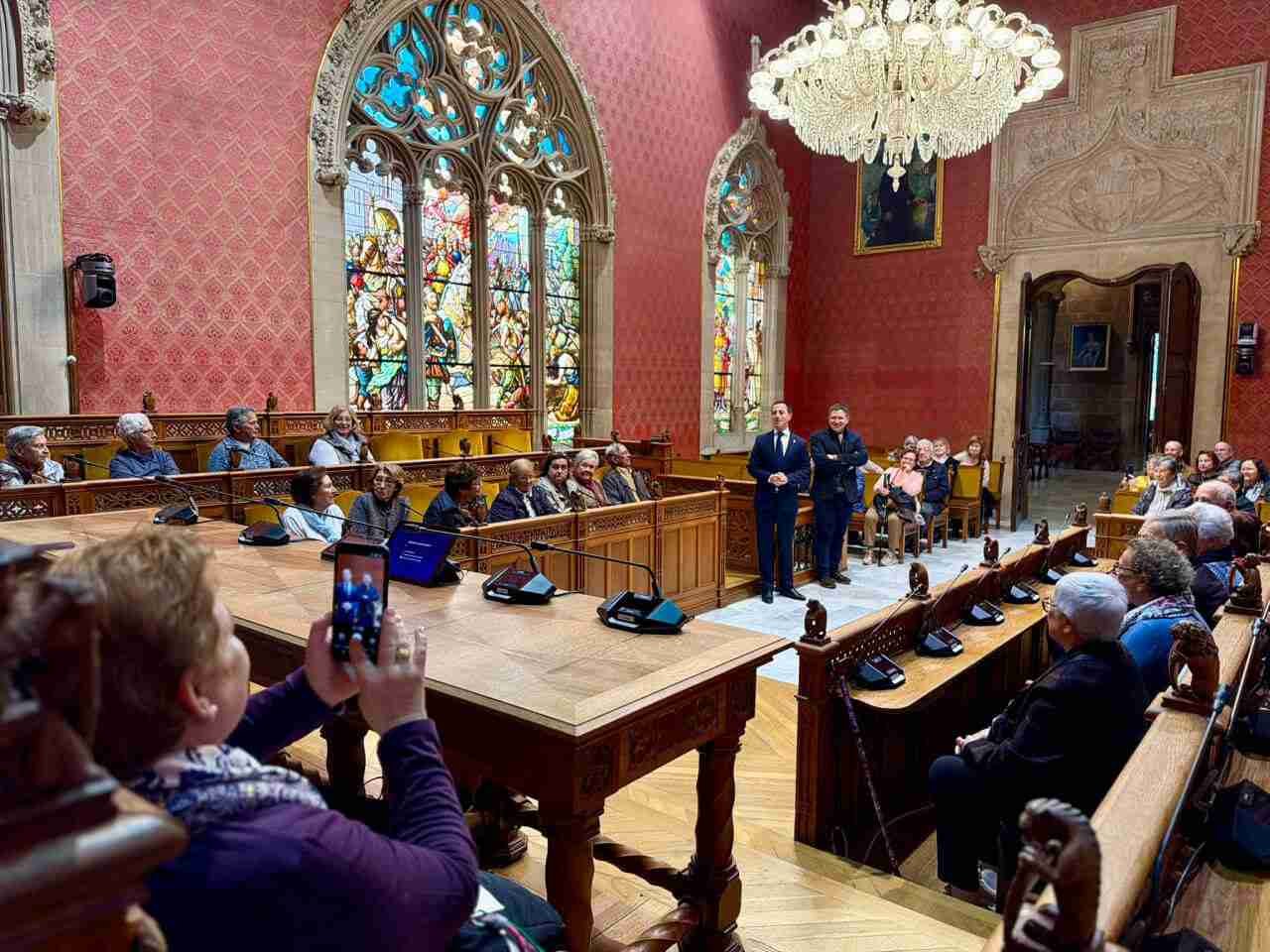 Grupo de personas durante una visita guiada en la sala de plenos del Palacio del Consell