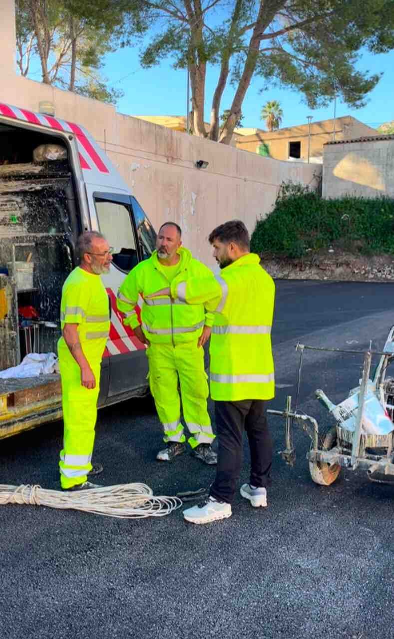 El concejal Bernat Grimalt a pie de calle dando instrucciones a dos operarios de movilidad junto a una furgoneta técnica