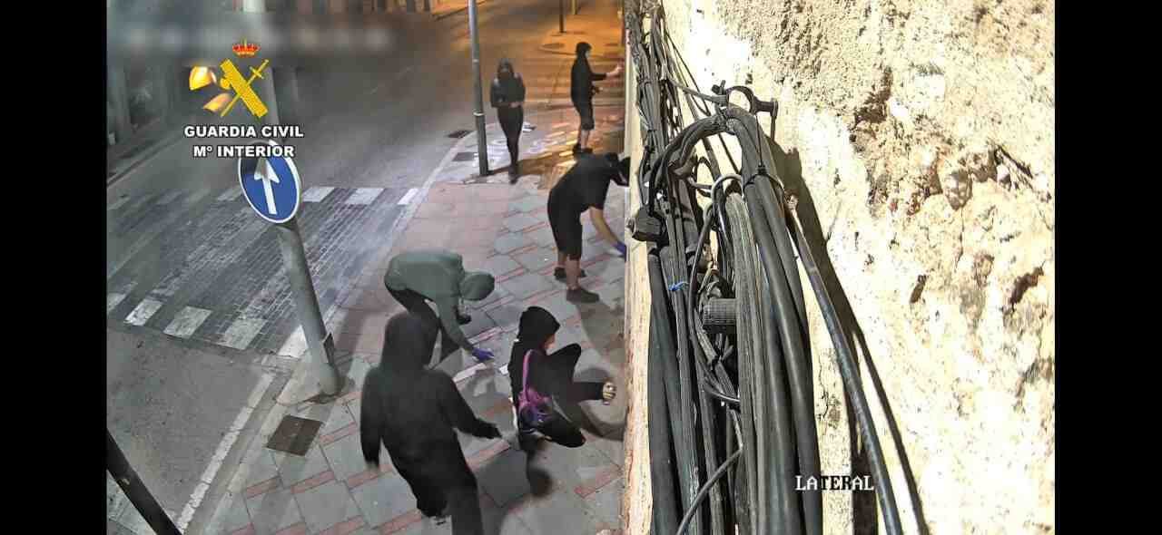 Grabación de cámara de seguridad donde se observa a varios de los implicados encapuchados realizando pintadas vandálicas en una fachada