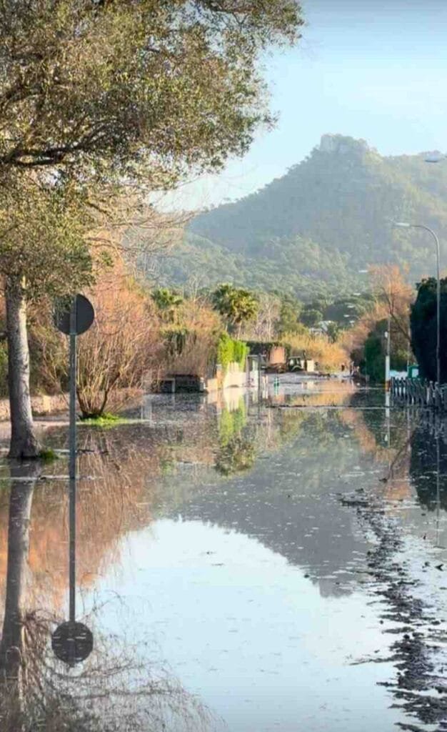 Calzada completamente inundada por el agua cubriendo la señalización vial en el acceso a la Costa de los Pinos
