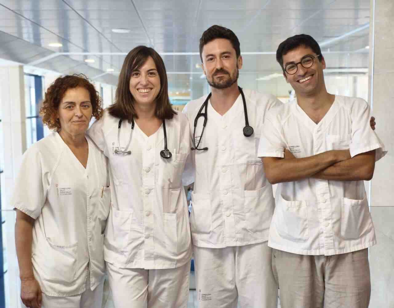 Cuatro profesionales del personal sanitario del Hospital de Inca posan sonrientes en un pasillo
