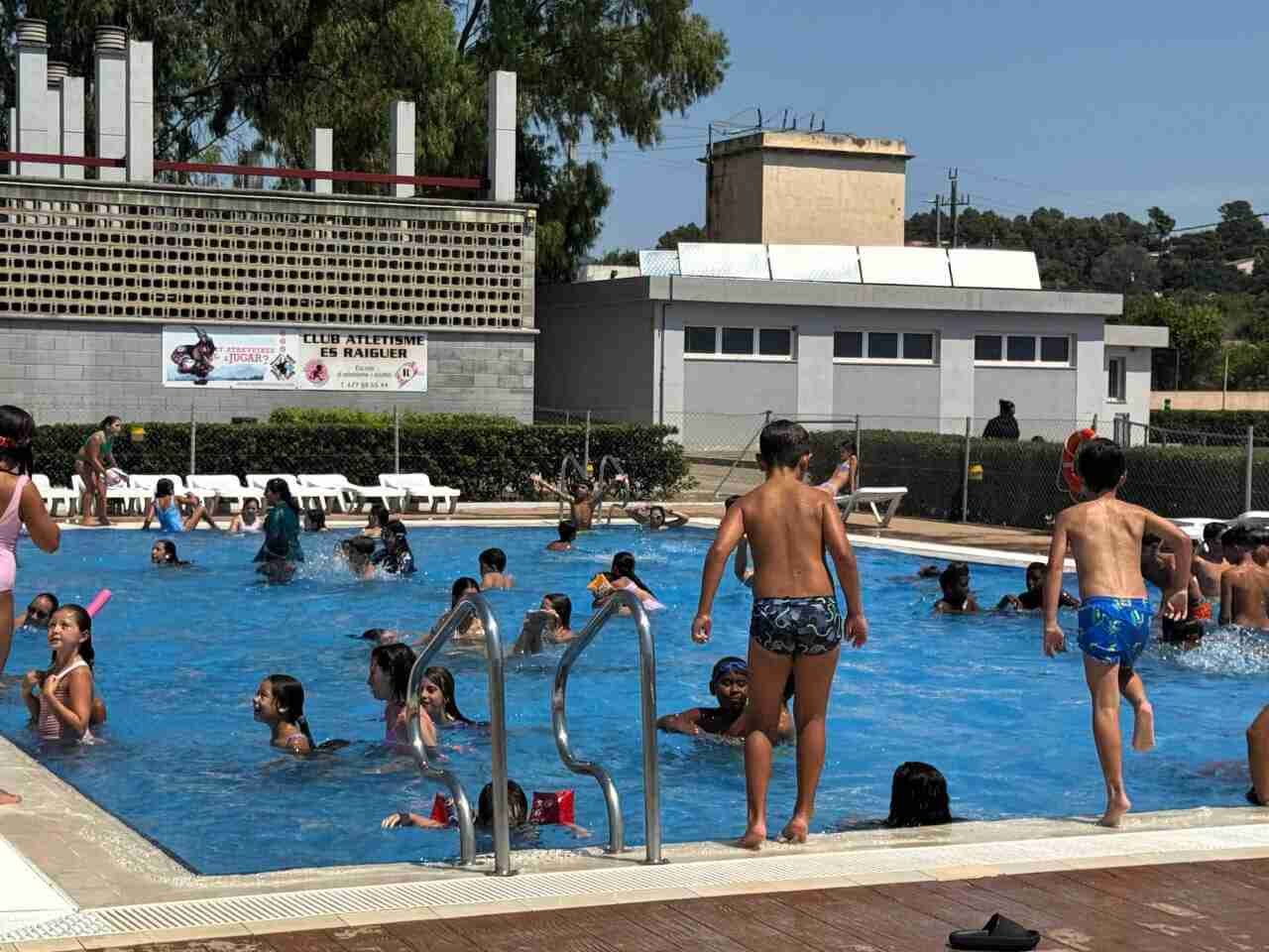 Grupo de niños y jóvenes bañándose y disfrutando en la piscina municipal de Inca durante las actividades de verano