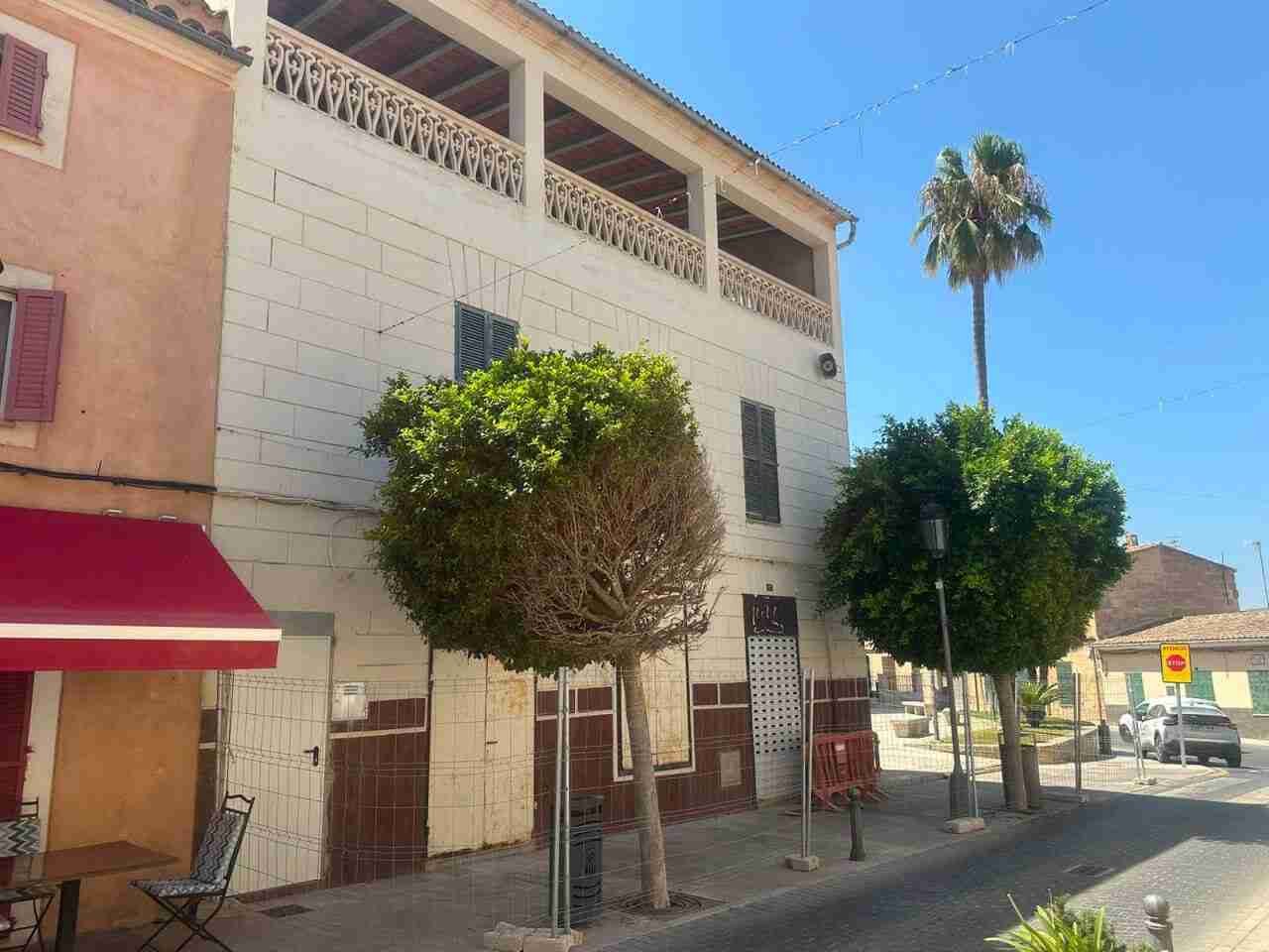 Fachada del edificio del carrer Major 15 de Son Carrió cercada por vallas de obra para su derribo