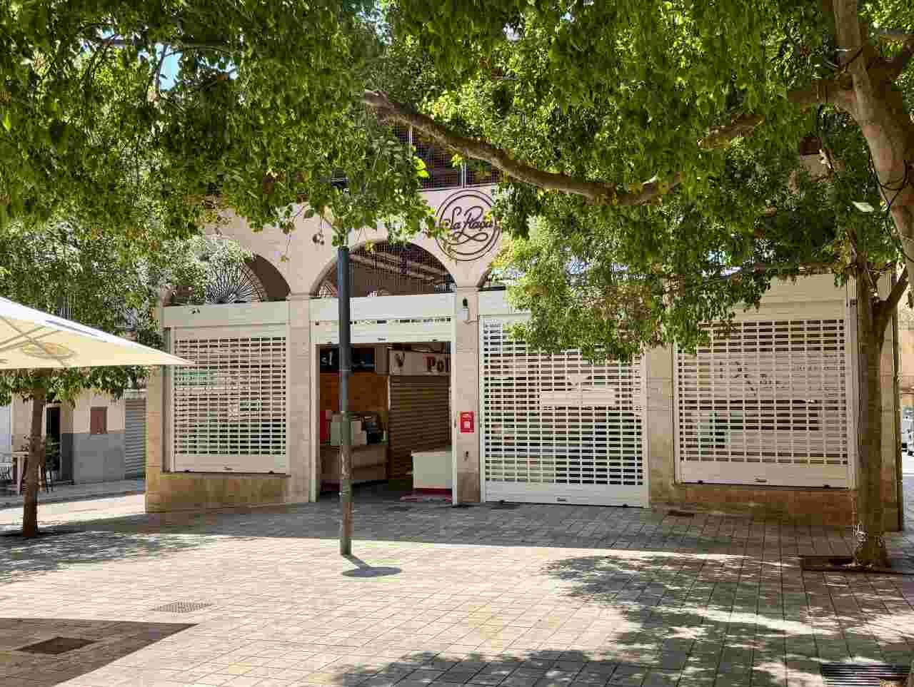 Vista exterior de los puestos comerciales cerrados con persianas metálicas en la plaza de las Verduras de Manacor