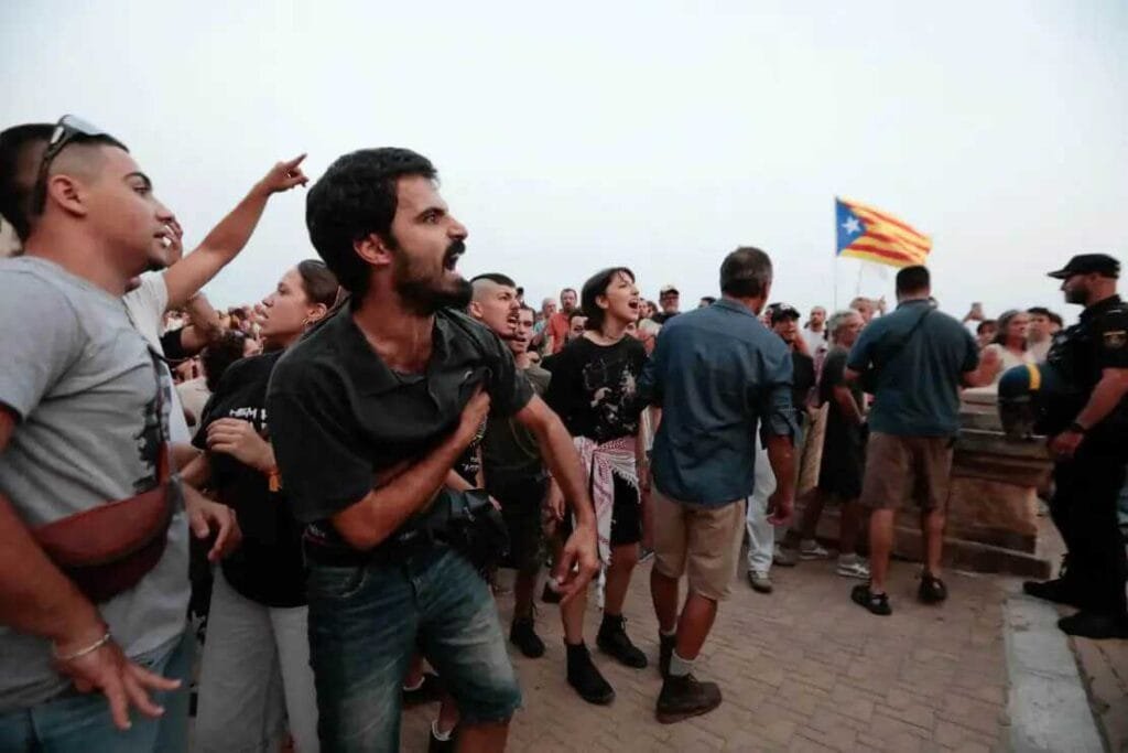 Manifestante joven gritando acaloradamente ante la línea de la Policía Nacional
