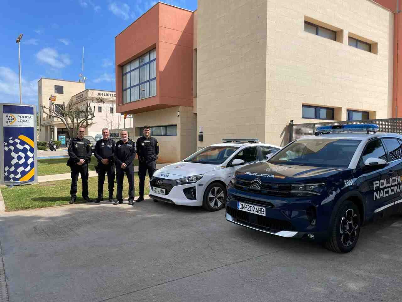 Cuatro mandos de la Policía Local y de la Policía Nacional junto a dos vehículos patrulla frente a las dependencias policiales