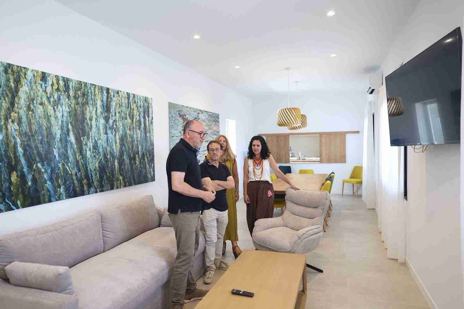 Autoridades políticas y responsables de Estel de Llevant visitando el salón de una de las nuevas viviendas supervisadas en el edificio Sa Ràfia