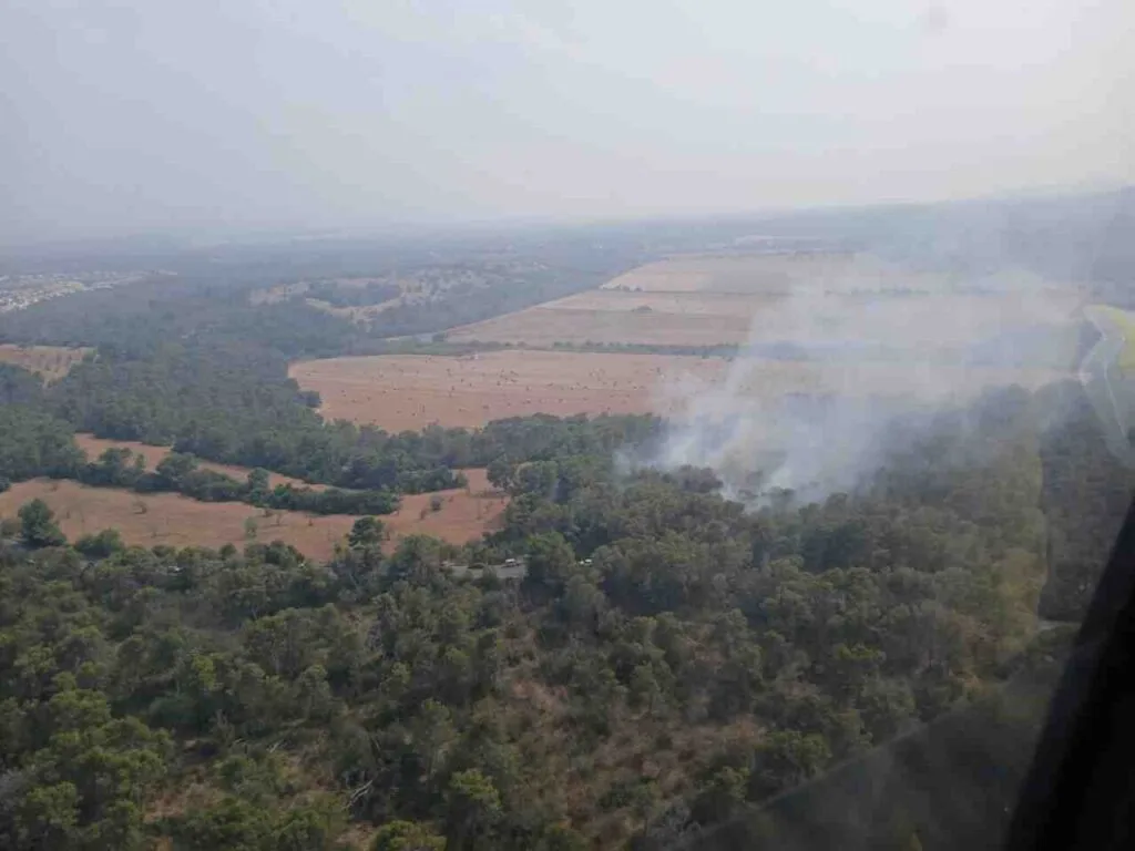 Vista aérea lejana del humo generado por el fuego en los pinares próximos a Cala Murada