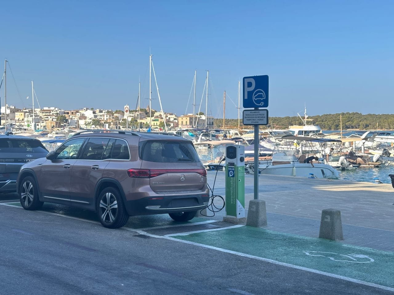 Vehículo eléctrico conectado a un punto de recarga municipal en el puerto de Portocolom en Felanitx