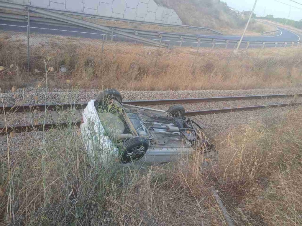 Coche blanco volcado sobre la vía del tren entre Petra y Manacor