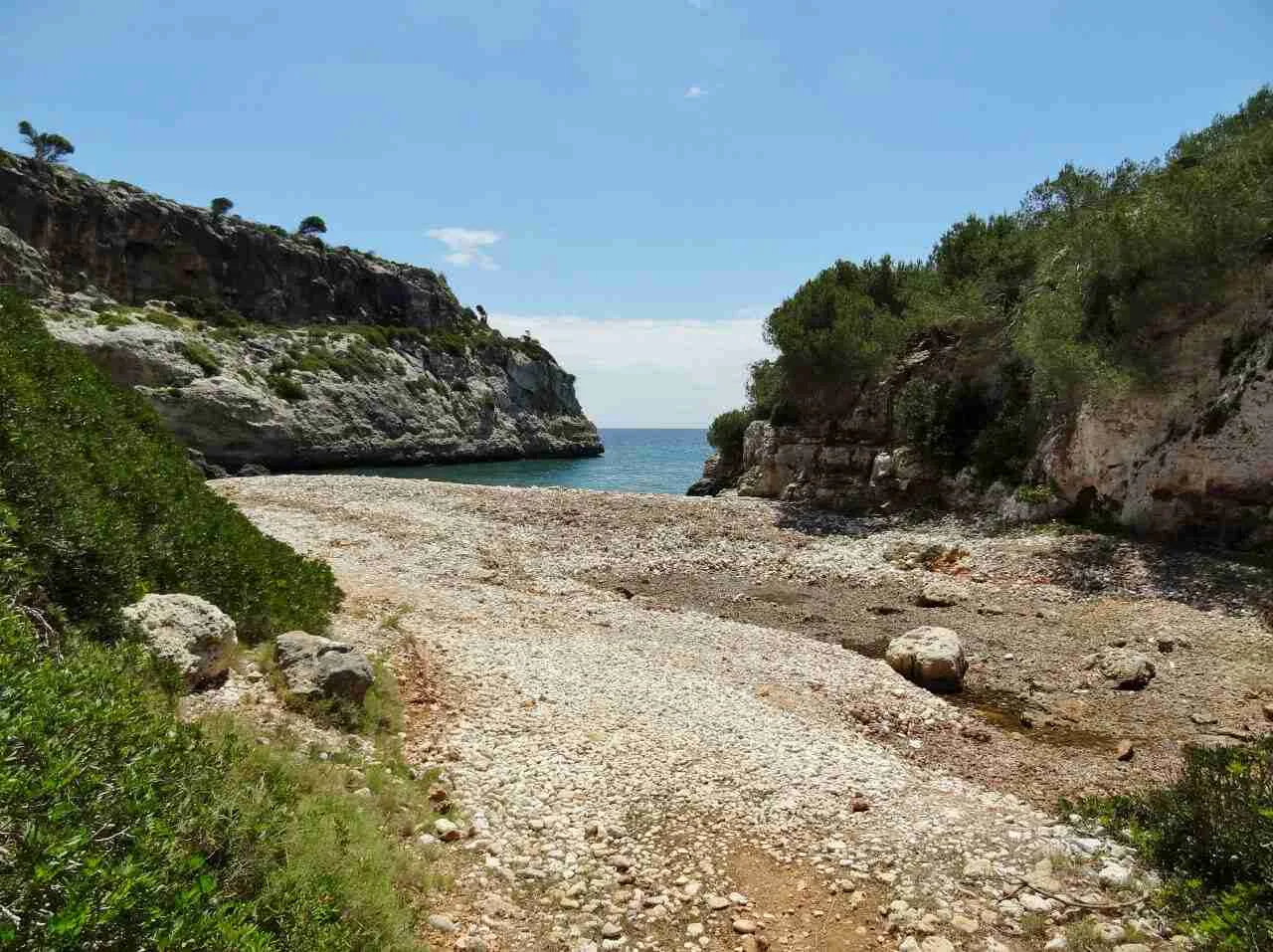 Vista de la cala de piedras y el mar al fondo en Cala Bota, Manacor