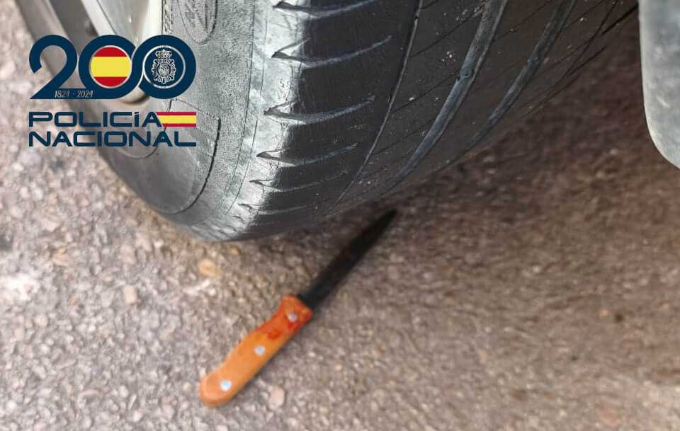 Cuchillo con manchas de sangre tirado en el suelo bajo la rueda de un vehículo