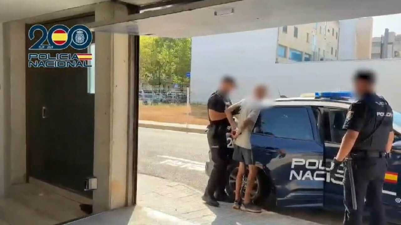 Agentes de la Policía Nacional introducen en el coche patrulla al detenido por robos en garajes de Manacor