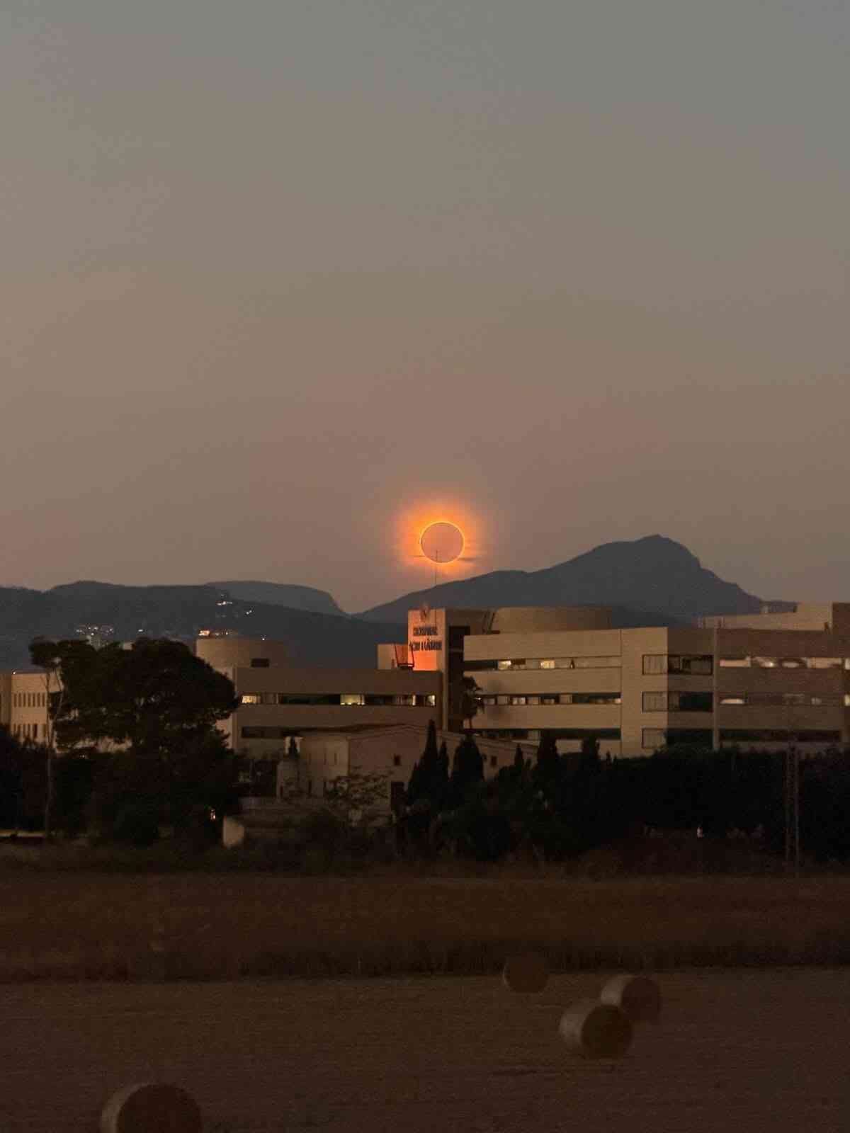 El eclipse solar iluminando el cielo anaranjado sobre las instalaciones del Hospital Son Llàtzer