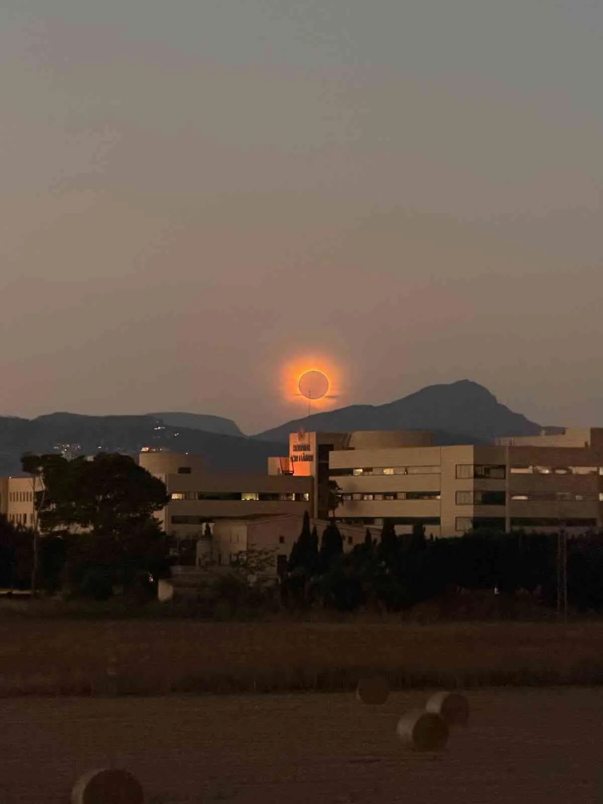 El eclipse solar iluminando el cielo anaranjado sobre las instalaciones del Hospital Son Llàtzer