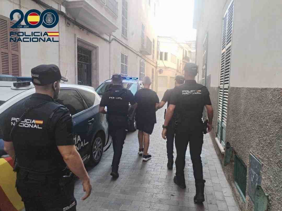 Agentes de la Policía Nacional conduciendo a un detenido por una calle cercana a los juzgados de Manacor