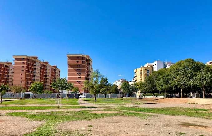 Vista general del parque Wi-fi de Palma con zonas de césped y edificios al fondo